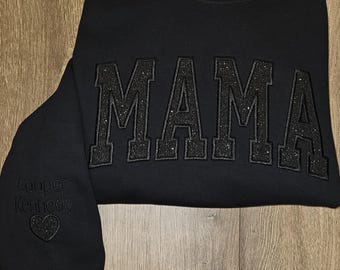 Sudadera MAMA negra sobre negra con purpurina y nombres en las mangas
