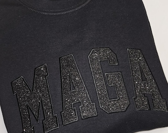 Camiseta o sudadera MAGA con purpurina negra sobre negra