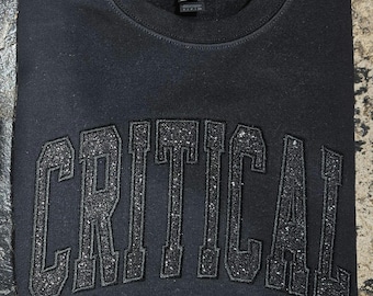Camiseta o sudadera negra sobre negra de Cuidados Críticos