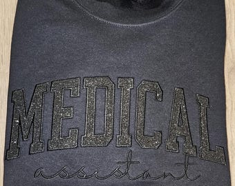 Camiseta o sudadera de asistente médico con purpurina negra sobre negro