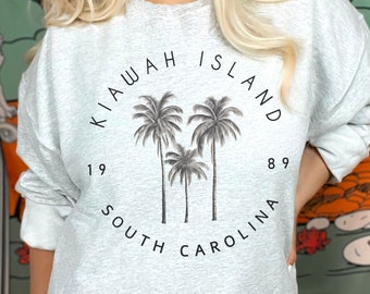 May include: Gray sweatshirt with a graphic print of palm trees and the text "Kiawah Island 1989 South Carolina".