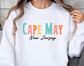 May include: White sweatshirt with the text "CAPE MAY" in colorful letters and "New Jersey" in black script.