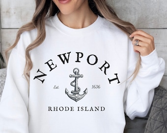 May include: White sweatshirt with black text that reads "NEWPORT Est. 1636 RHODE ISLAND" and a black and white anchor graphic.