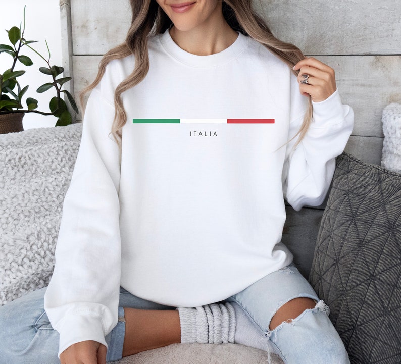 May include: White sweatshirt with a green, white, and red stripe across the chest and the word "ITALIA" printed below the stripe.