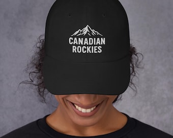 May include: Black baseball cap with the text "CANADIAN ROCKIES" in white, along with a mountain range graphic. The cap is a classic style, suitable for outdoor activities or casual wear.