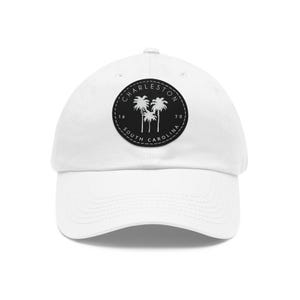 May include: White baseball cap with a black patch featuring the text "CHARLESTON SOUTH CAROLINA" and a graphic of three palm trees.