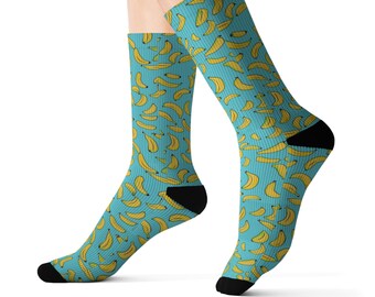 May include: A pair of blue socks with a yellow banana pattern. The socks are shown on a model's feet.