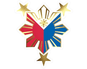 Op de afbeelding: Een sticker met het embleem van de Filipijnse vlag. Het ontwerp omvat een rood en blauw zonnesymbool met een centrale ster en drie gouden sterren. Het embleem is goud omrand.