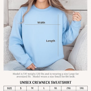 May include: A light blue Gildan 18000 unisex crewneck sweatshirt. The image includes a size chart with measurements in inches for sizes S to 5XL. The model is 5'4" and weighs 120 lbs, wearing a size Large for an oversized fit.