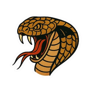 Könnte beinhalten: Ein Aufkleber mit einer detaillierten Illustration eines Kobrakopfes. Der Schlangenkopf ist braun mit schwarzen Akzenten, offenem Maul, scharfen Fangzähnen und einer roten Zunge. Das Design hat einen Vintage-Tattoo-Stil.