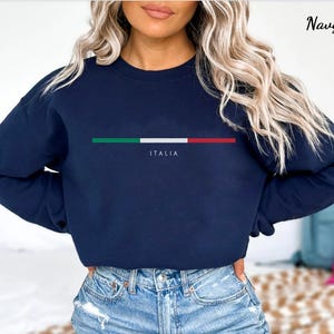 May include: Navy blue long-sleeved sweatshirt with a horizontal stripe of the Italian flag colors and the word "ITALIA" printed below the stripe.