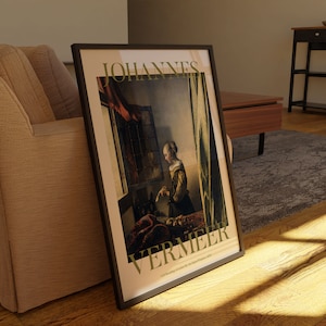 Pode incluir: Impress&atilde;o art&iacute;stica emoldurada de "Girl Reading a Letter by an Open Window, 1657" de Johannes Vermeer. A impress&atilde;o, com moldura preta, exibe a pintura com texto na parte superior e inferior. A obra de arte retrata uma mulher lendo uma carta perto de uma janela.