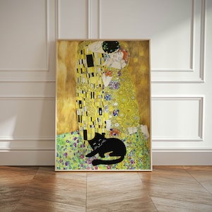 May include: Framed art print featuring a stylized depiction of a couple embracing, inspired by Gustav Klimt's 'The Kiss'. The artwork is predominantly gold, yellow, and black, with a black cat lounging in the foreground. The print is in a wooden frame.