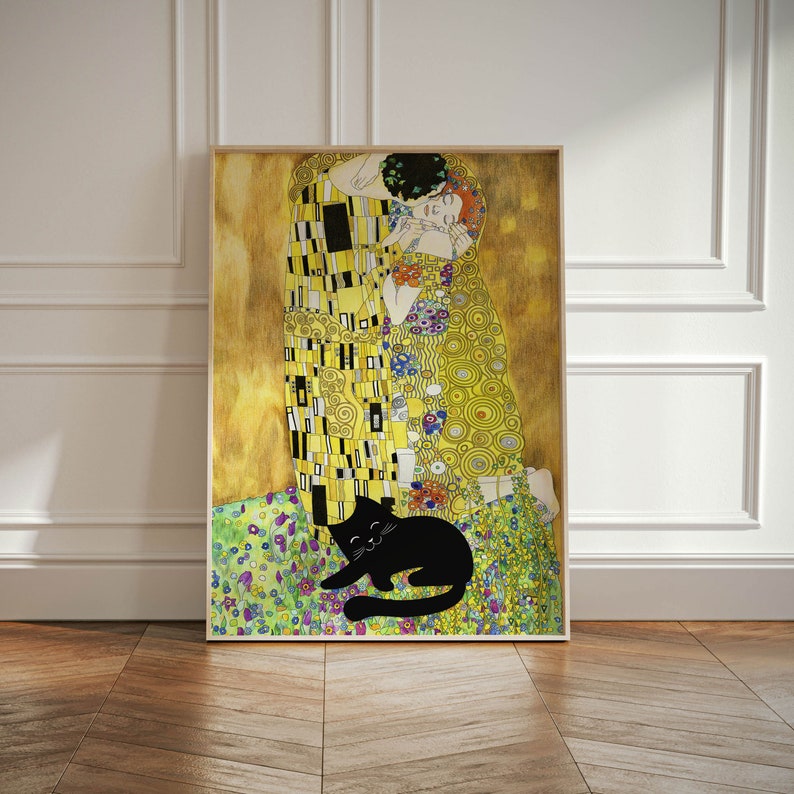 May include: Framed art print featuring a stylized depiction of a couple embracing, inspired by Gustav Klimt's 'The Kiss'. The artwork is predominantly gold, yellow, and black, with a black cat lounging in the foreground. The print is in a wooden frame.