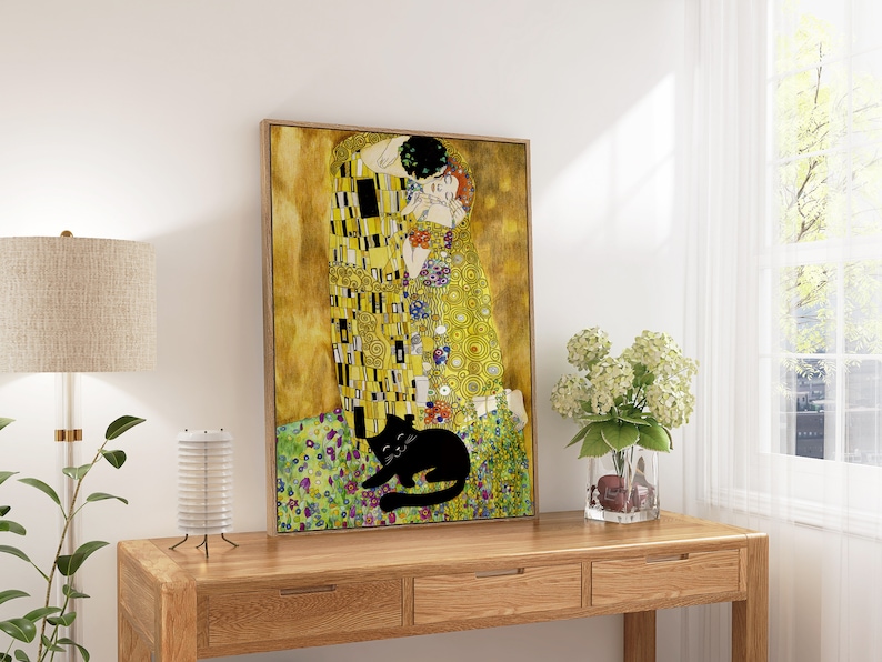 May include: A framed print of Gustav Klimt's "The Kiss" with a black cat illustration. The artwork features gold, yellow, and colorful accents. The print is displayed on a wooden console table, with a lamp and flowers.