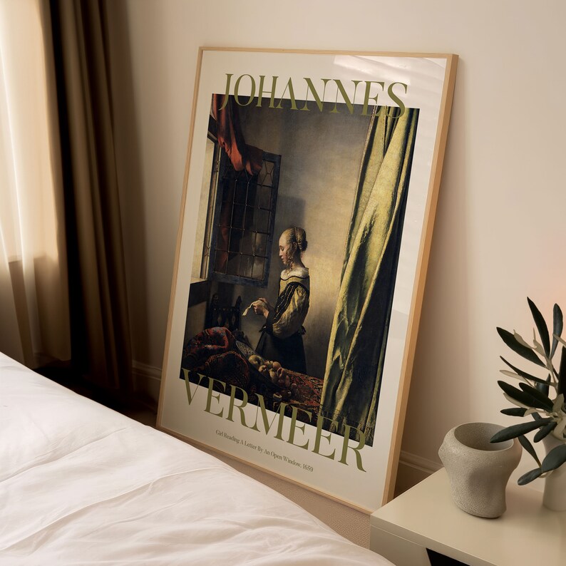 Pode incluir: Uma impress&atilde;o art&iacute;stica emoldurada de "Mo&ccedil;a lendo uma carta junto &agrave; janela aberta" de Johannes Vermeer. A impress&atilde;o tem uma moldura de madeira clara e mostra a pintura com suas cores suaves e sua representa&ccedil;&atilde;o detalhada de uma mulher lendo. O texto "JOHANNES VERMEER" &eacute; impresso no topo.