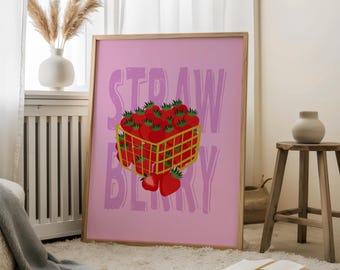 Puede incluir: Un estampado enmarcado con un fondo rosa y la palabra "STRAWBERRY" en fuente morada clara. Una cesta amarilla llena de fresas rojas con hojas verdes está en el centro. El estampado se exhibe en una habitación con una ventana y una alfombra blanca.