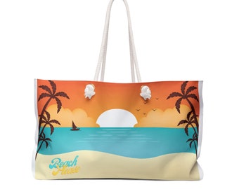 May include: A white canvas tote bag with a sunset scene and palm trees. The bag has white rope handles and the text "Beach Please" in yellow.