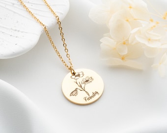 May include: Gold necklace with a round pendant featuring an engraved floral design and the word "Family".