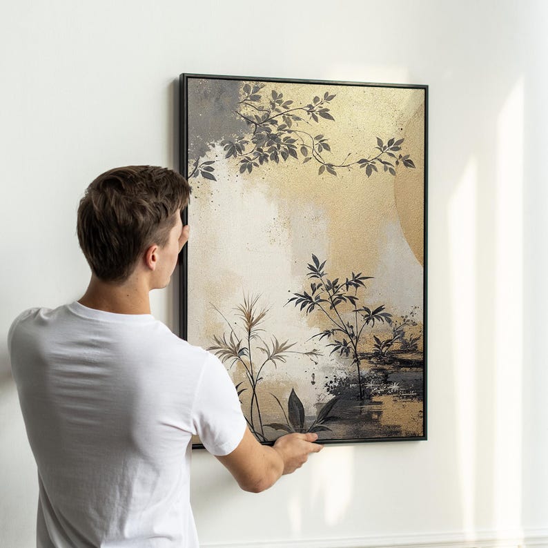Pu&ograve; includere: Una stampa d'arte astratta incorniciata con uno sfondo dorato e piante stilizzate in nero e grigio. La stampa &egrave; appesa a una parete bianca.