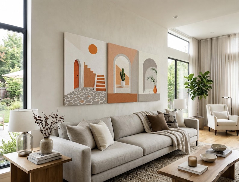 May include: A triptych wall art set featuring three panels with abstract architectural scenes in warm earth tones. The artwork displays arched doorways, a staircase, a sun, a potted cactus, and a palm plant, rendered in shades of orange, beige, and gray.