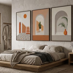 May include: A set of three framed wall art prints featuring architectural scenes with arches, a cactus in a pot, a palm plant in an orange vase, a staircase, and a sun, rendered in a palette of terracotta, beige, white, and gray tones.