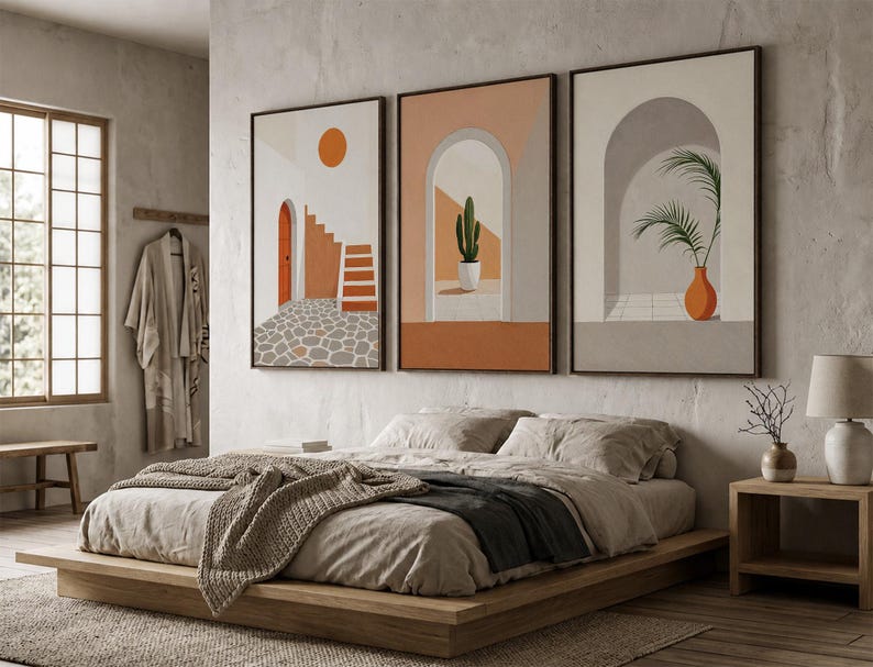 May include: A set of three framed wall art prints featuring architectural scenes with arches, a cactus in a pot, a palm plant in an orange vase, a staircase, and a sun, rendered in a palette of terracotta, beige, white, and gray tones.