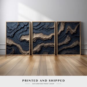 May include: Three abstract art prints with a blue and brown color scheme. The prints feature a textured, layered design that resembles a mountain range.
