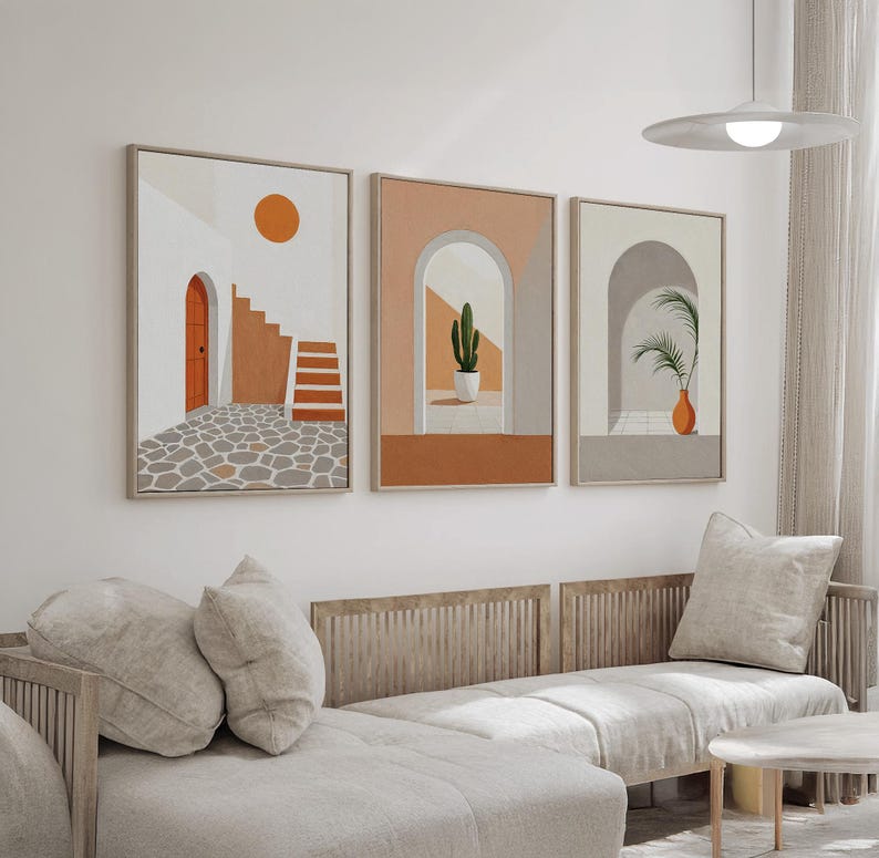 May include: A set of three framed wall art prints featuring architectural scenes. The first shows a stone patio, orange door, and stairs. The second depicts an arched doorway with a potted cactus. The third displays an arched entryway with a palm plant.