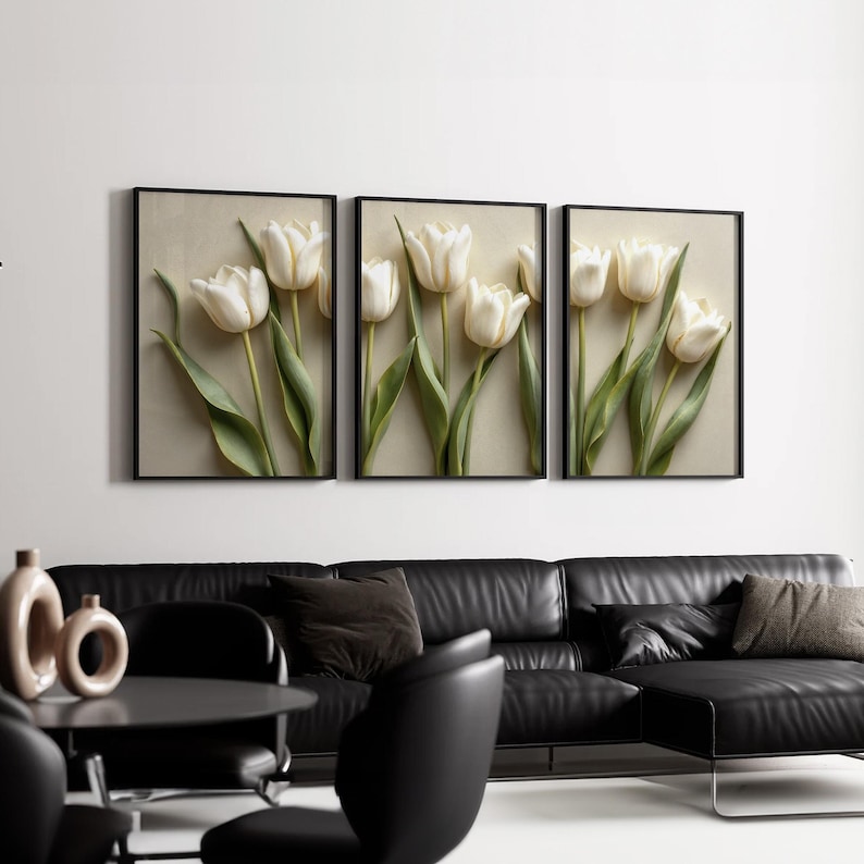 May include: Three framed wall art pieces featuring white tulip flowers with green stems and leaves. The artwork is set against a neutral background and framed in black. The overall theme is floral and decorative.