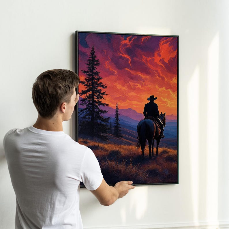 K&ouml;nnte beinhalten: Ein gerahmtes Gem&auml;lde, das einen einsamen Cowboy zeigt, der auf einem Pferd in einen Sonnenuntergang reitet. Der Himmel ist leuchtend orange und rot mit Wolken. Der Cowboy tr&auml;gt einen Hut und einen langen Mantel. Das Pferd ist braun und hat eine lange M&auml;hne und einen langen Schweif. Das Gem&auml;lde ist vor dem Hintergrund von B&auml;umen und Bergen gemalt.
