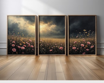 May include: Three framed art prints depicting a field of wildflowers under a dramatic sky. The artwork features pink and yellow flowers in a meadow, with a stormy sky overhead. The frames are a light wood color.