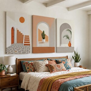 May include: A set of three rectangular canvas wall art prints featuring architectural scenes with arches, stairs, a potted cactus, and a palm plant in a color palette of terracotta, white, gray, and orange, displayed above a wooden bed frame.