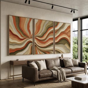 May include: A triptych wall art set featuring three rectangular canvases with a continuous abstract design of flowing, wavy lines in shades of burnt orange, sage green, cream, and tan, all encased in thin, light-coloured wooden frames.