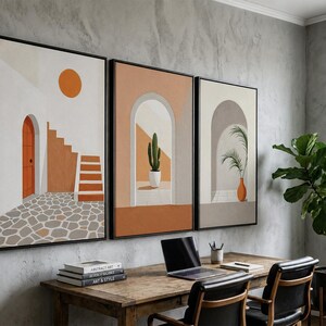 May include: A set of three framed wall art prints featuring architectural scenes with arched doorways, a cactus in a white pot, a palm plant in an orange vase, stone flooring, and a bright orange sun against a neutral background.
