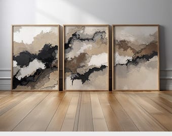 May include: Three framed abstract art prints. Each print features a textured design with a palette of black, white, and tan. The frames are a light wood color. The prints are displayed on a wooden floor.