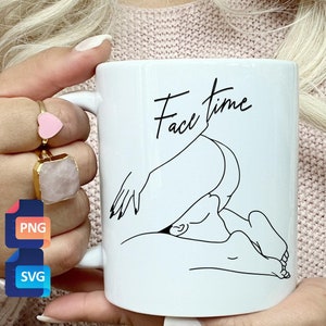 Könnte beinhalten: Eine weiße Keramiktasse mit einer schwarzen Linienzeichnung von zwei Personen, die sich umarmen. Der Text "Face Time" ist in schwarzer Kursivschrift über der Zeichnung geschrieben.