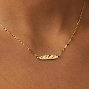 Collar con colgante de baguette chapado en oro de 24 quilates con forma de pan de masa madre.