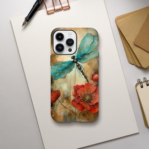 Puede incluir: Una funda para teléfono con una libélula y flores rojas sobre un fondo de madera. La funda tiene un recorte para la cámara y un borde blanco.