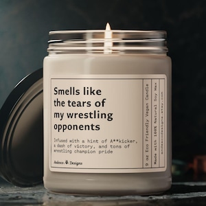 May include: A 9 ounce soy wax candle in a glass jar with a black lid. The candle is labeled "Smells like the tears of my wrestling opponents" and is infused with a hint of a**kicker, a dash of victory, and tons of wrestling champion pride.
