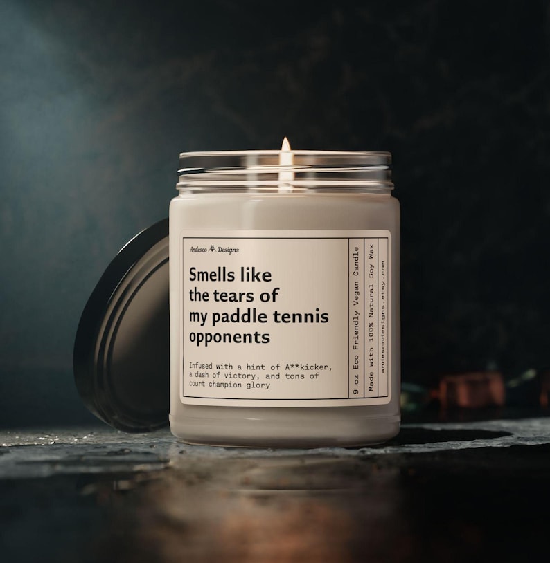 a funny paddle tennis candle  that says smells like the tears of my paddle tennis opponents - Infused with a hint of A**kicker, a dash of victory, and tons of court champion glory