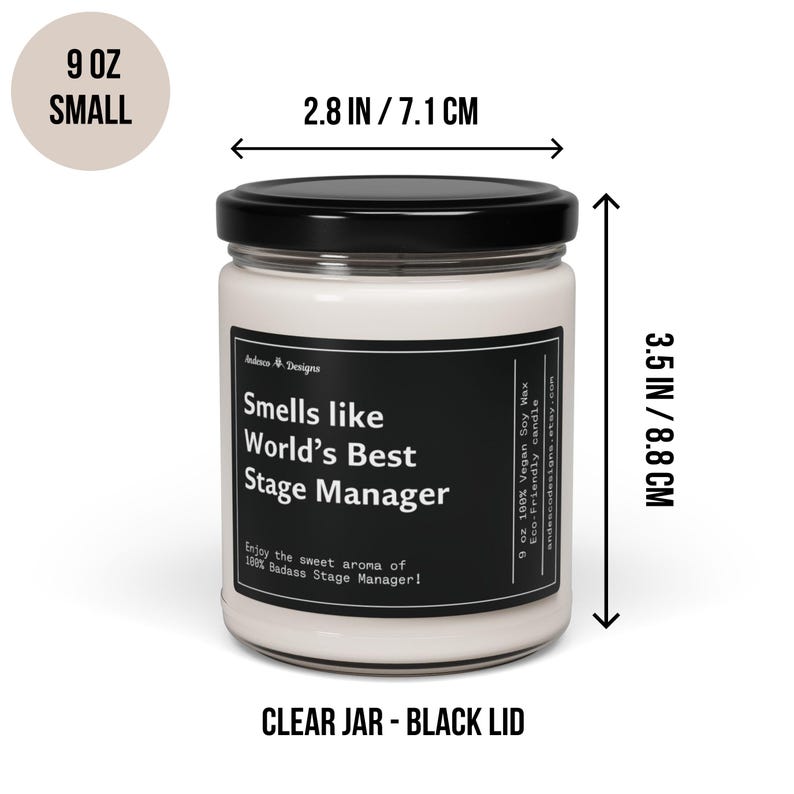 May include: A 9 ounce soy wax candle in a clear glass jar with a black lid. The candle is labelled "Smells like World's Best Stage Manager". The jar is 7.1 cm wide and 8.8 cm tall.