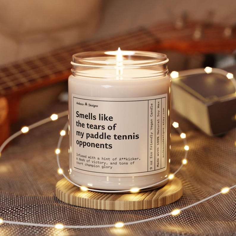 a funny paddle tennis candle  that says smells like the tears of my paddle tennis opponents - Infused with a hint of A**kicker, a dash of victory, and tons of court champion glory
