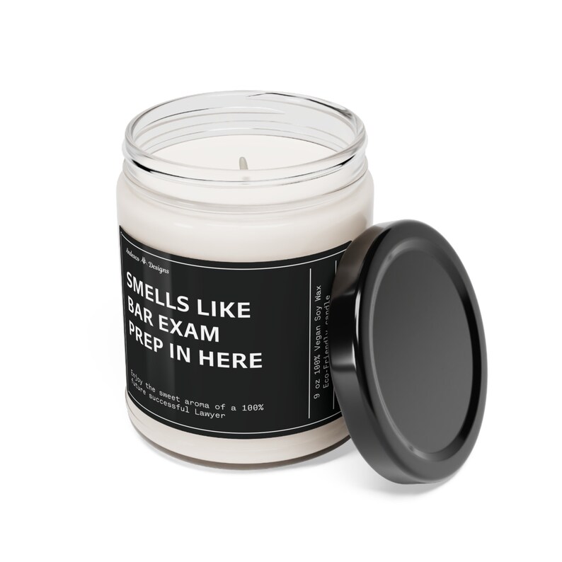 May include: A black and white candle jar with the text "Smells Like Bar Exam Prep In Here" and "Enjoy the sweet aroma of a 100% sure successful Lawyer". The candle jar is 9 ounces and made with 100% vegan soy wax. The lid is black and is off the jar.