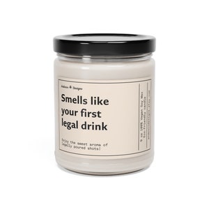 May include: A 9 ounce soy wax candle in a clear glass jar with a black lid. The candle is labeled "Smells like your first legal drink" and "Enjoy the sweet aroma of legally poured shots!"