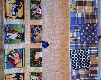 May include: A long fabric organizer featuring three distinct vertical panels. The left panel displays a repeating grid of various dog breeds in colorful frames. The center panel is a solid beige speckled fabric. The right panel is a blue and brown patchwork quilt design.