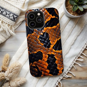 May include: A black phone case with a snakeskin pattern in shades of orange and brown.