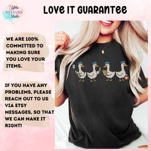May include: Black t-shirt featuring a line of cartoon geese wearing blue hats, each holding a medical item. The shirt also has the text "Love It Guarantee" and a guarantee of customer satisfaction.