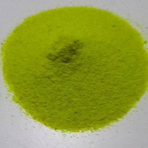 May include: A pile of bright green sand, likely used for crafts or decorative purposes.