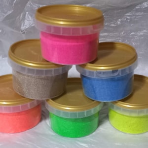 May include: Six containers of colorful glitter, each in a clear plastic container with a gold lid. The colors are pink, brown, blue, orange, green, and yellow.